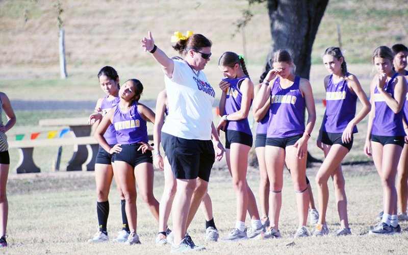 District 28-2A cross-country meet director Michelle Winkenwerder goes over a few things with the varsity girls contestants. Photos by Mark Lube.