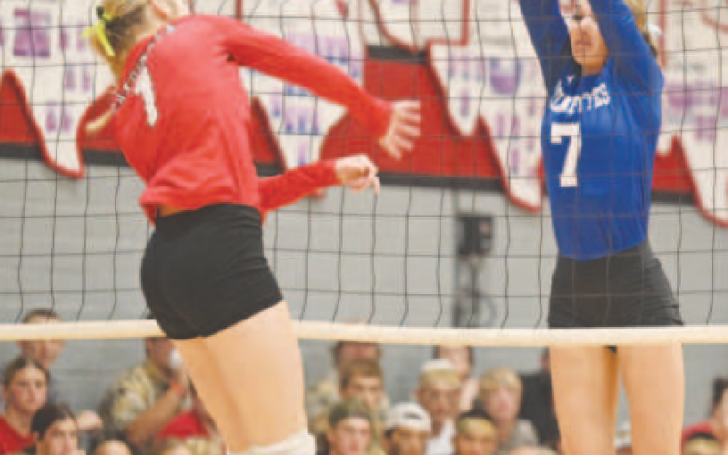 Rylan Dworsky (7) goes up to block an attempted kill by St. Paul’s Riley Mozisek. Chuck Grafe/Tribune-Herald