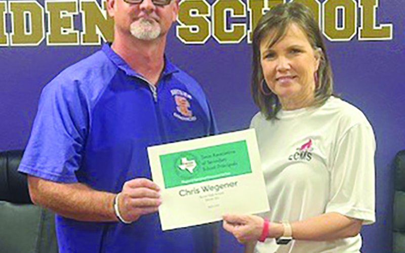 Sandy Nesser, a representative from Region III, hands Chris Wegener the award for High School Principal of the Year for Region III. Photo by Clayton Kelley.