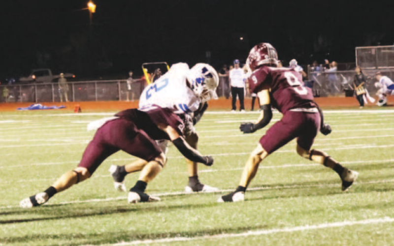 Carter Blaha (21) and Trace Butschek (9) come up to make the tackle on Yoakum’s Tre Cuellar. Chuck Grafe/TribuneHerald