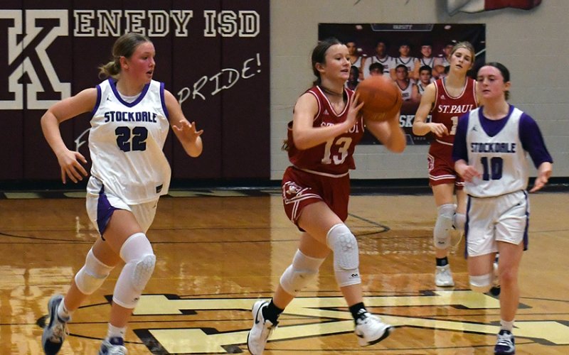 St. Paul’s Reese Chilek (center) passes the ball off during the Lady Cardinals Dec. 20 game against Stockdale in the Kenedy Tournament tournament. Photo by Mark Lube.