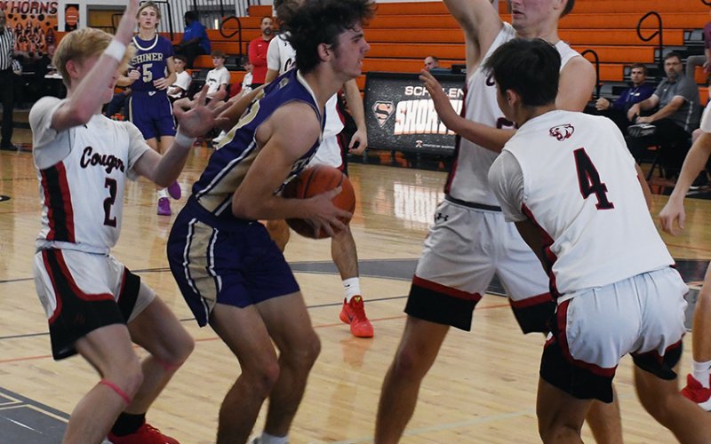 Carson Schuette battles a Brazos triple team Friday in the Schulenburg Tournament. The game was the Comanches’ regular-season opener. Photo by Mark Lube.