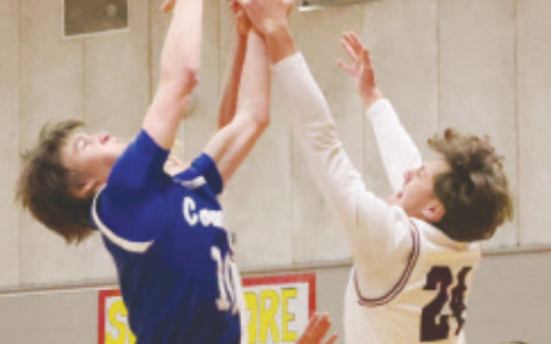 Kason Podhajsky (24) and Edna’s Brady Peters vie for a rebound. Chuck Grafe/Tribune-Herald