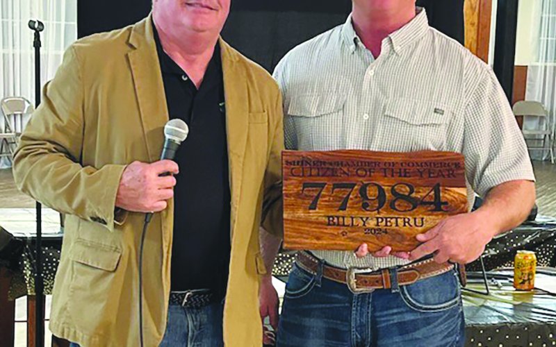 Board Chairman Mike Campbell, left, presents the Citizen of the Year award to Billy Petru, right.