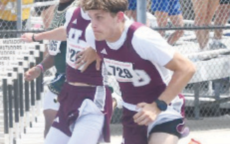 Caden Willis, foreground, and Shane Migura in the 100 relay. Mark Lube/ Shiner Gazette
