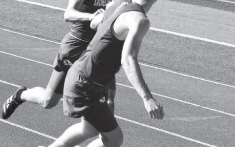 Layne Sevcik hands off to Andrew Steffek in the 100 relay. Photo by Karen Janak