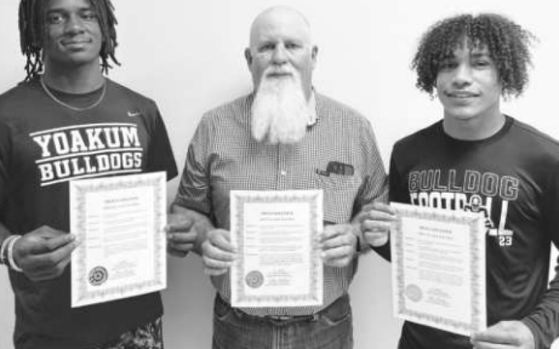 X’Zavier Barnett placed 6th in the triple jump and Trae Cuellar placed 9th in the triple jump at the recent 2025 state Track Meet in Austin. Pictured from left to right are Barnett, Yoakum High School (YHS) Bulldog Track Coach Gary Garvin, and Cuellar. The students were honored at the Yoakum ISD May 12 School Board meeting. YHT Staff photo.