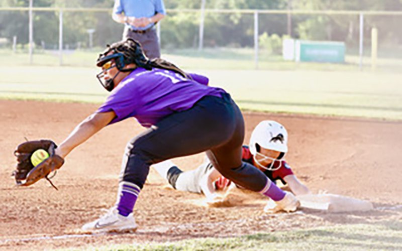 -Patricia Price gets the throw from catcher Charlotte Hairell on a throw down to first.  Photo by Nicole Smith.