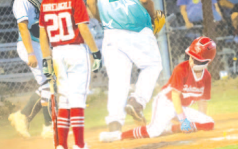 Photo by Chuck Grafe Cullen Hanslik scores on a wild pitch in the victory over Luling.
