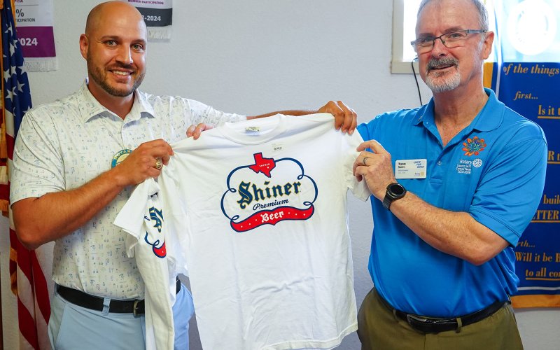 Jared Barnes, Shiner Rotary President, presents Todd Smith with a Shiner shirt as a welcome gift