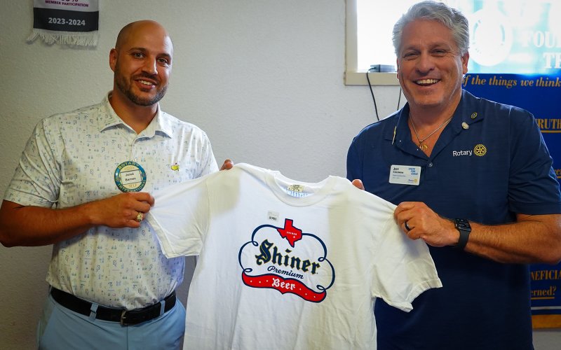 Jared Barnes, Shiner Rotary President, presents Jeff Coleman with a Shiner shirt as a welcome gift