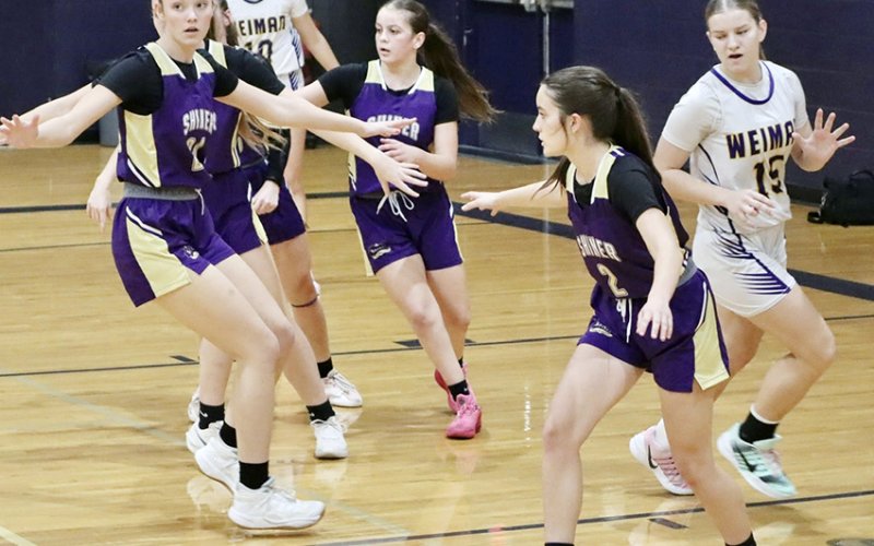 Lady Comanches Evy Johnson (left), Emersyn Boehm (middle) and Marie Johnson (right) in action against Weimar on Friday. Photo courtesy of Louann Heinhsohn.
