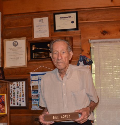  Bill Lopez poses in front of a wall decorated with his awards in mid-May. Photo by Hans Lammeman.