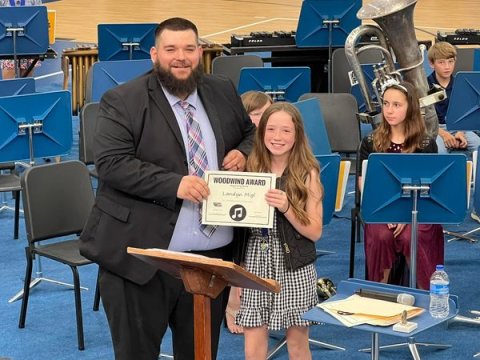 Jacob Heck presents an award to one of his band students over at Sacred Heart schools last school year.