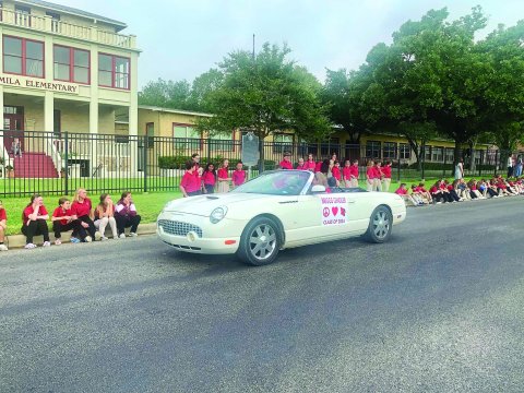 Shown in the photo is the grandparent of 1st grader Briggs Gindler as she rolls slowly past the junior high students