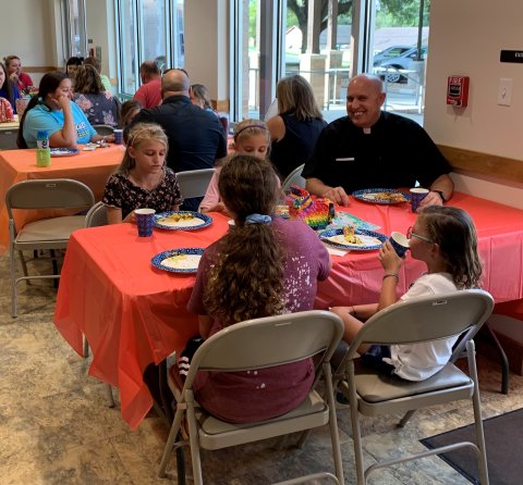Pictured is Pastor Chris Heinhold enjoying a meal with children at Wednesday evening GIFT.