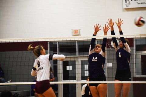 Flatonia gets a ball past the block attempt of Avery Boedeker and Aimee Mitchon. Photo by Mark Lube.