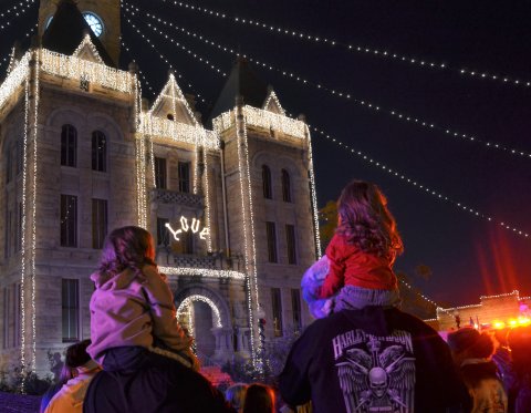 Children sit atop shoulders for a better view of the Hallettsville Festival of Lights parade Saturday night, Nov. 26.