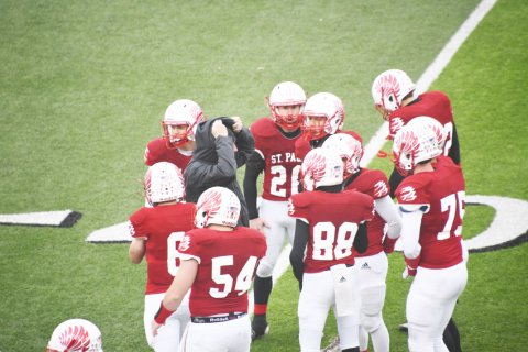 The Cardinals get last-minute instructions prior to the opening kickoff. Photo by Mark Lube.