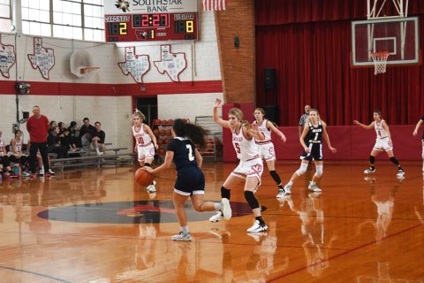 A Lady Ram player changes plan because of the defensive stance and pressure of St. Paul's Riley Mozisek. Photo by Mark Lube.