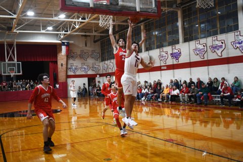 Sam Perez  puts up a first-half shot as an Saints player applies some defensive pressure. Perez contributed three points. Photo by Mark Lube.