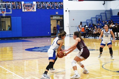 A Lady Brahmas player attempts to dispossess Madison Gonzales during the first half. Photo by Mark Lube.
