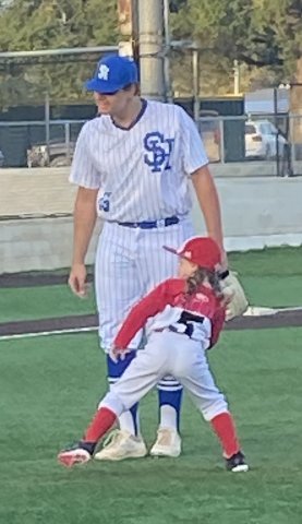Quinn Janak throws out the first pitch for Sacred Heart vs. St. Paul baseball game.