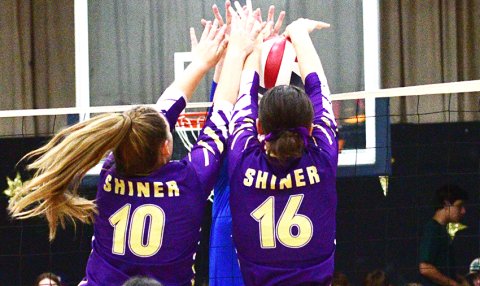Chelsea Whiddon (left) and Morgan Lenehan (right) perform a double block at Hallettsville Sacred Heart on Aug. 22. Photo by Chuck Grafe/Hallettsville Tribune-Herald.