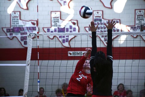 Tori Walker puts a shot over the net with Austin San Juan Diego attempting to block the kill attempt Sept 5. The Lady Cardinals won the district match in three games. Photo by Mark Lube. 