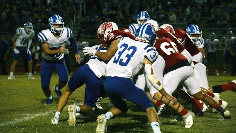 The St. Paul offensive line makes a push against the Sacred Heart defensive line. Photo by Mark Lube.