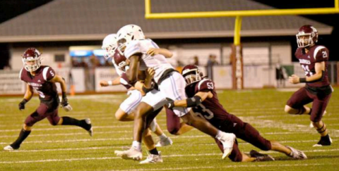 Defensive end Austin Lala tackles Warriors’ John Kelly for a first period loss. Chuck Grafe/Tribune-Herald