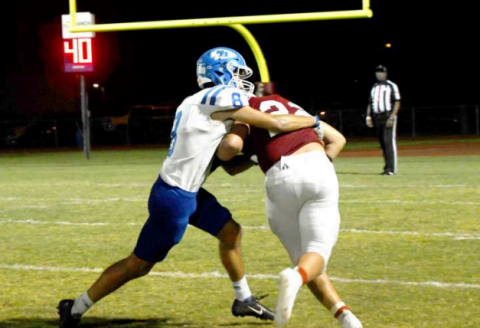 Nic Angerstein collars St. Paul Cardinal halfback Nate Boedeker. Mark Lube/Shiner Gazette