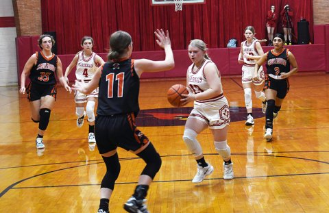 Maurin Knesek moves the ball into the lane while a Schulenburg player tries to contain her.  Photo by Mark Lube.