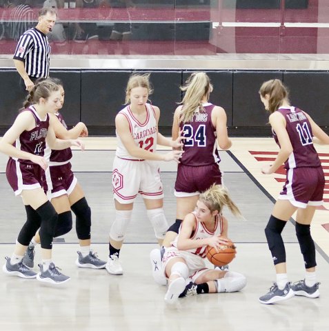 Dallyn Pesek takes a seat on the floor to claim the ball and then looks for open teammate in the Lady Cards’ Fayetteville Tournament game against Flatonia. Sloane Kocian is also in on the play. Photo courtesy of Louann Heinsohn.