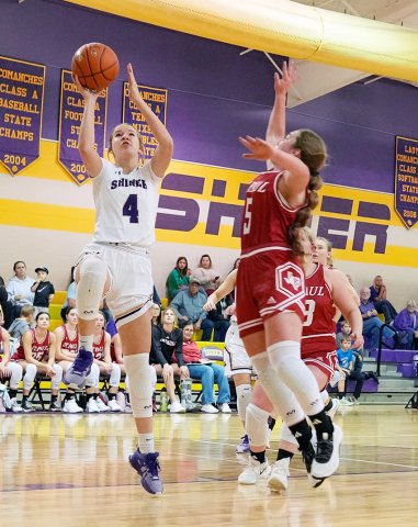 Lady Comanche Aimee Mitchon (left) tries for a bucket while being defended by St. Paul’s Presley Tuch. Photo courtesy of Howard Esse. 