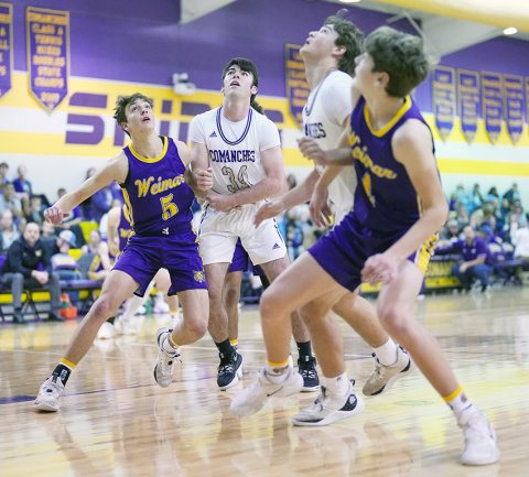 Comanches Kyle Muehlstein (second from left) and Jared Werner (second from right) battle Weimar players for an offensive rebound during the first half of Shiner’s 49-28 win over the Wildcats on Friday. Photo courtesy of Howard Esse.