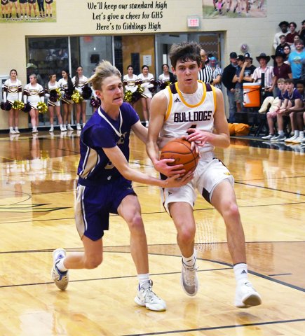 Sophomore Boe Boehm (left) wrestles with a Thorndale player for possession of the ball in the 2A bi-district Feb. 20 at Giddings High School. Photo by Mark Lube.