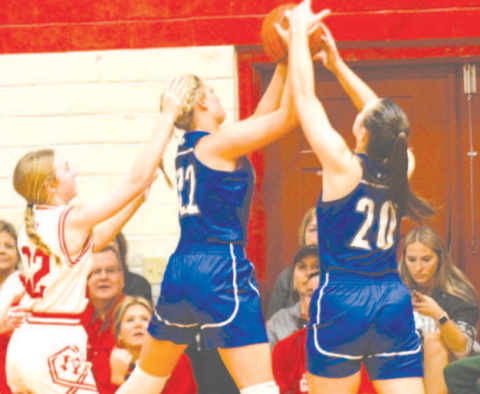 Kaycee Schindler (22) and Ava Lackey (20) grab a rebound during the victory over St. Paul. Chuck Grafe/Tribune-Herald