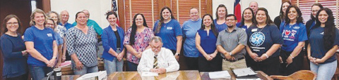 Members of SJRC Texas-Belong receive a proclamation from DeWitt County Commissioners declaring April 2024 as National Child Abuse Prevention Month. DeWitt County Judge Daryl Fowler, center, signs the proclamation at the March 25 meeting.