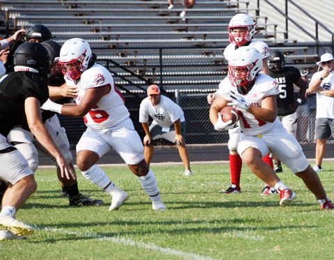 St. Paul running back Sam Perez follows behind his blockers Thursday evening in St. Paul’s scrimmage with Schulenburg and Bartlett in Schulenburg. Photo by Mark Lube. 