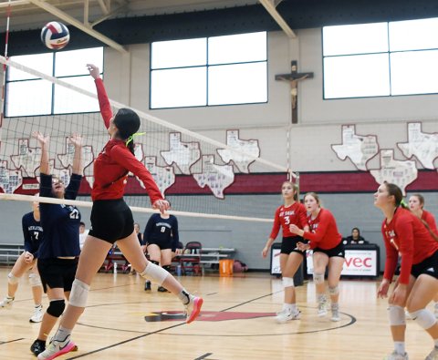 Erin Hajek makes a play at the net while teammates look on. She had two kills against Faith Lutheran. Photo by Mark Lube.