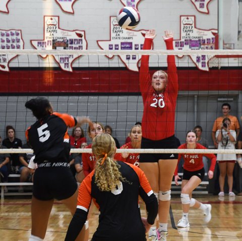 Emery Kennedy jumps up to block a kill attempt by Smithville’s Briyanna Sampson (right) during the Lady Cardinals’ three-set win on Thursday. Photo by Mark Lube.