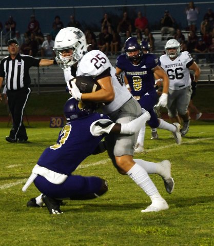 Shiner’s Jarvis Williams gets ahold of Industrial receiver Logan Thomas during the first quarter. Photo by Mark Lube.
