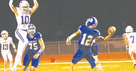 Indian quarterback Andrew Steffek gets off a pass despite the effort of St. Joseph’s Nick Bludau. Chuck Grafe/Tribune-Herald