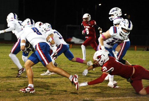 Truett Goodyk just manages to avoid a shoestring tackle by St. Paul’s Tyler Pendley Friday in the Cardinals’ home game against Bryan Brazos Christian. Photo by Mark Lube.
