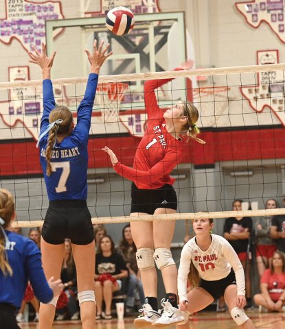 Riley Mozisek (right) jumps up to contact a set while Sacred Heart’s Rylan Dworsky attempts a block. St. Paul libero Tatum Walker looks on. Photo courtesy of Chuck Grafe/Hallettsville Tribune-Herald.