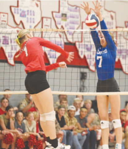 Rylan Dworsky (7) goes up to block an attempted kill by St. Paul’s Riley Mozisek. Chuck Grafe/Tribune-Herald