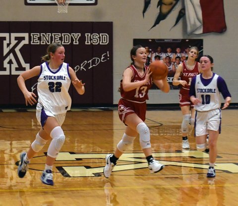 St. Paul’s Reese Chilek (center) passes the ball off during the Lady Cardinals Dec. 20 game against Stockdale in the Kenedy Tournament tournament. Photo by Mark Lube.