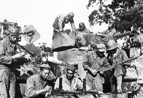 Soldiers from Dog Company of the 761st Tank Battalion check equipment before leaving England for combat in France in the fall of 1944. – U.S. Army photo