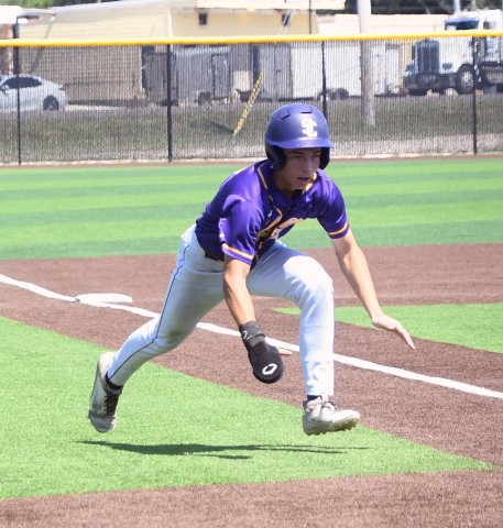 Runner Clayton Fric starts to slide towards home plate in the second inning of the second game against Falls City. He scored the opening run and scored three total runs. Photo by Mark Lube.